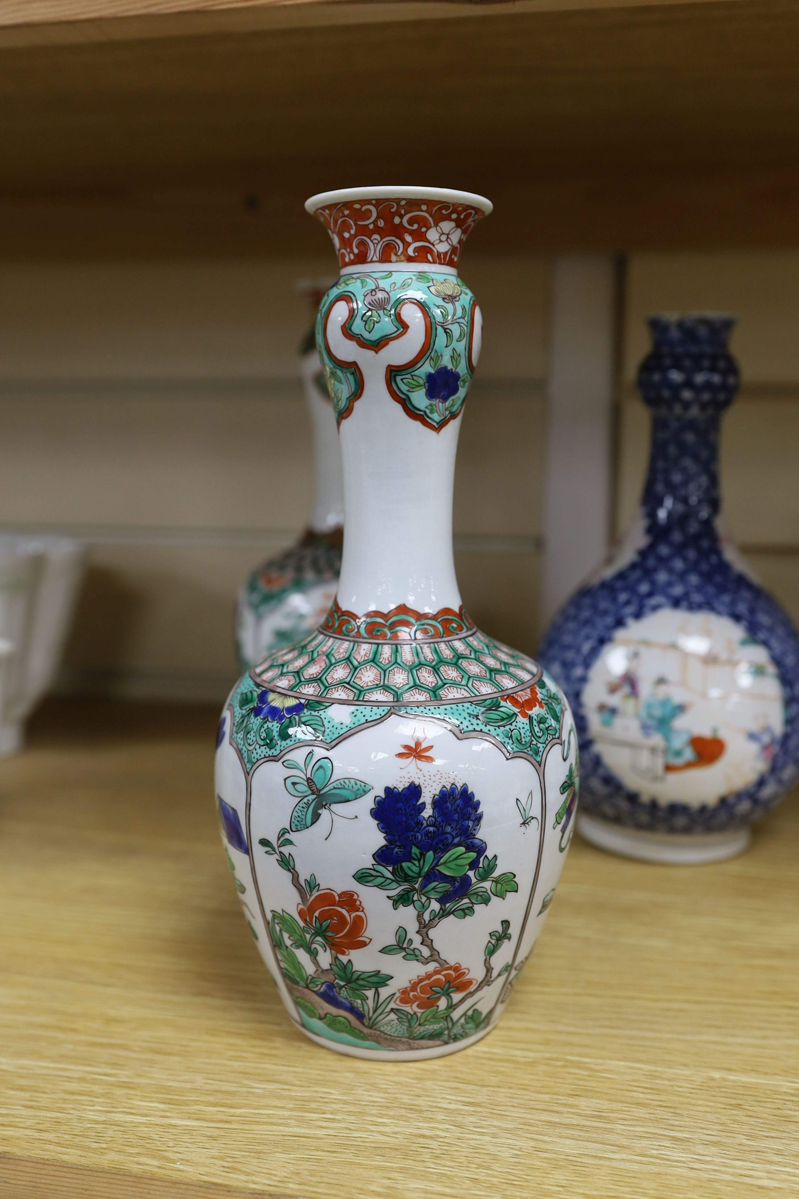 A pair Samson of Paris vases in the Chinese famille verte style and a Chinese Qianlong famille rose garlic neck vase with blue panelling motif, tallest 26cm